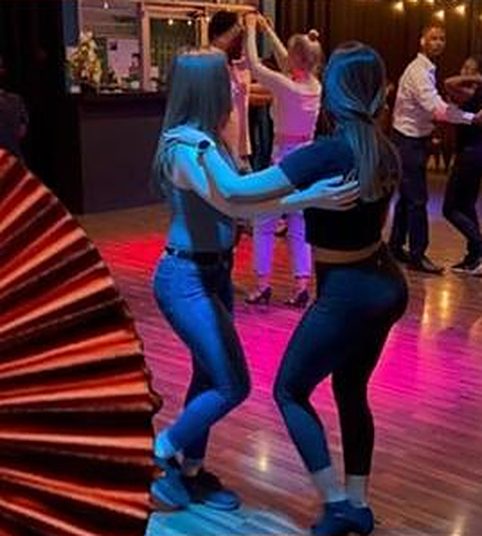 Two dancers under pink club lights